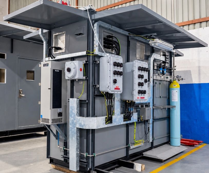 Analyzer shelters with hazardous-area junction boxes and gas cylinders in the AIC workshop